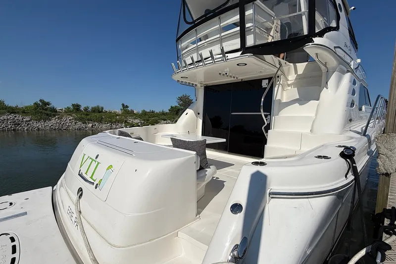 Slide: The Image of 2002 Sea Ray 560 Sedan Bridge yacht docked, featuring spacious deck and sleek design. - 18