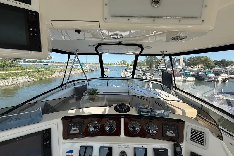 Slide: The Image of Interior view of 2002 Sea Ray 560 Sedan Bridge yacht, showcasing helm and marina backdrop. - 21