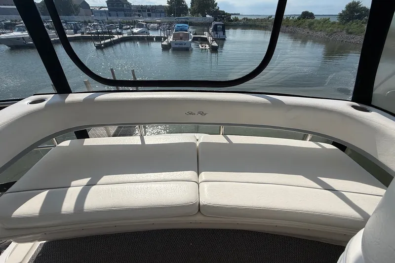 Slide: The Image of Interior view of 2002 Sea Ray 560 Sedan Bridge yacht with white seating and marina backdrop. - 36