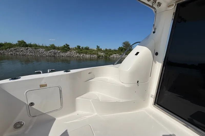 Slide: The Image of 2002 Sea Ray 560 Sedan Bridge yacht deck with serene water and shoreline view. - 16