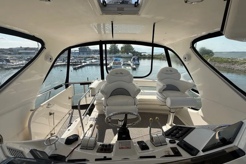 Slide: The Image of Interior view of 2002 Sea Ray 560 Sedan Bridge yacht cockpit with marina backdrop. - 46
