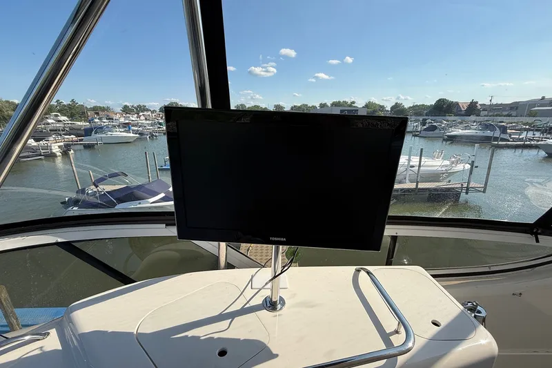 Slide: The Image of 2002 Sea Ray 560 Sedan Bridge helm with a Toshiba monitor, overlooking marina. - 27