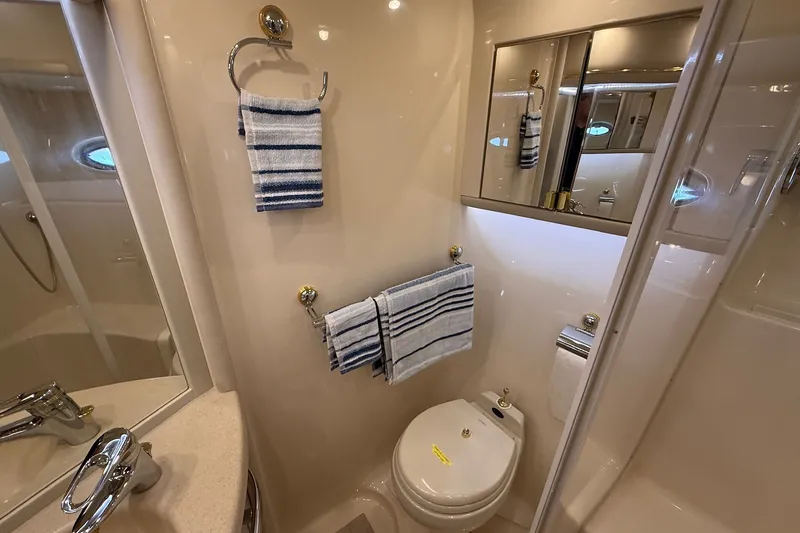 Slide: The Image of Luxurious bathroom in 2002 Sea Ray 560 Sedan Bridge yacht with striped towels and modern fixtures. - 87