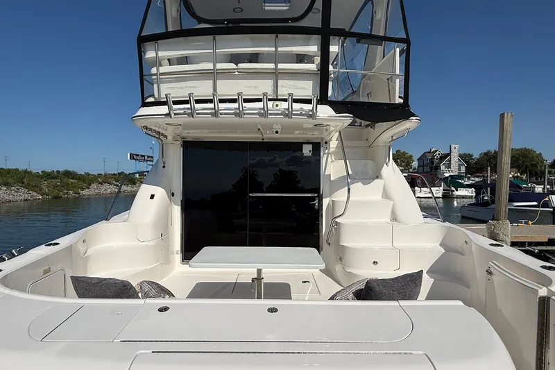 Slide: The Image of 2002 Sea Ray 560 Sedan Bridge yacht with spacious deck and seating area, docked at marina. - 10