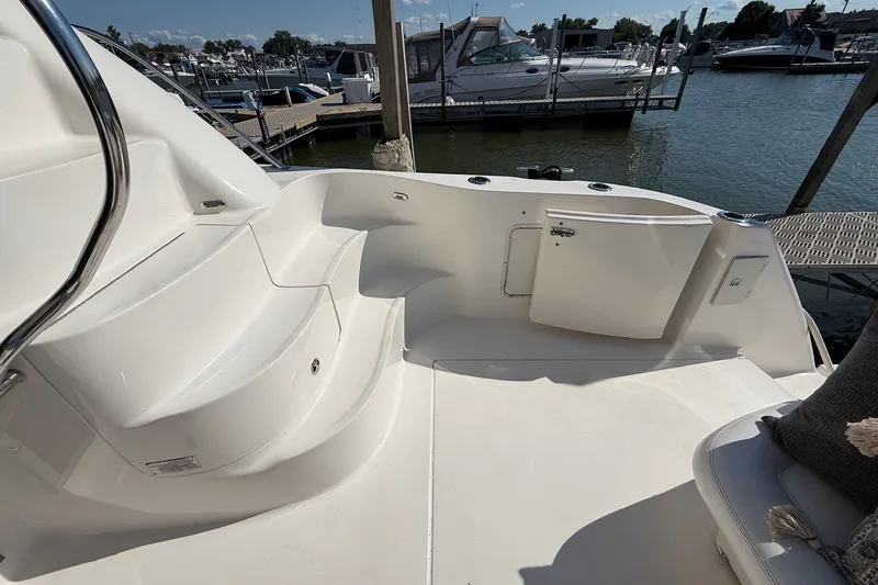 Slide: The Image of 2002 Sea Ray 560 Sedan Bridge yacht deck with seating, docked at marina. - 17