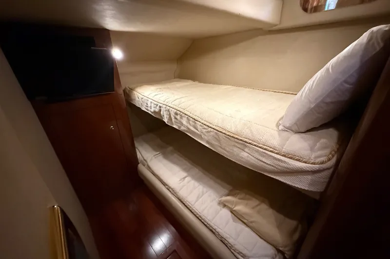 Slide: The Image of Bunk beds in 2002 Sea Ray 560 Sedan Bridge yacht cabin, featuring cozy lighting and wood accents. - 78