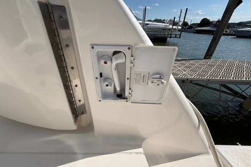 Slide: The Image of 2002 Sea Ray 560 Sedan Bridge boat water hookup panel by a dock. - 48