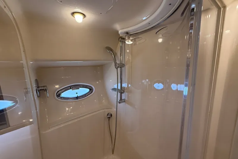 Slide: The Image of Luxurious bathroom in 2002 Sea Ray 560 Sedan Bridge yacht with shower and porthole window. - 89