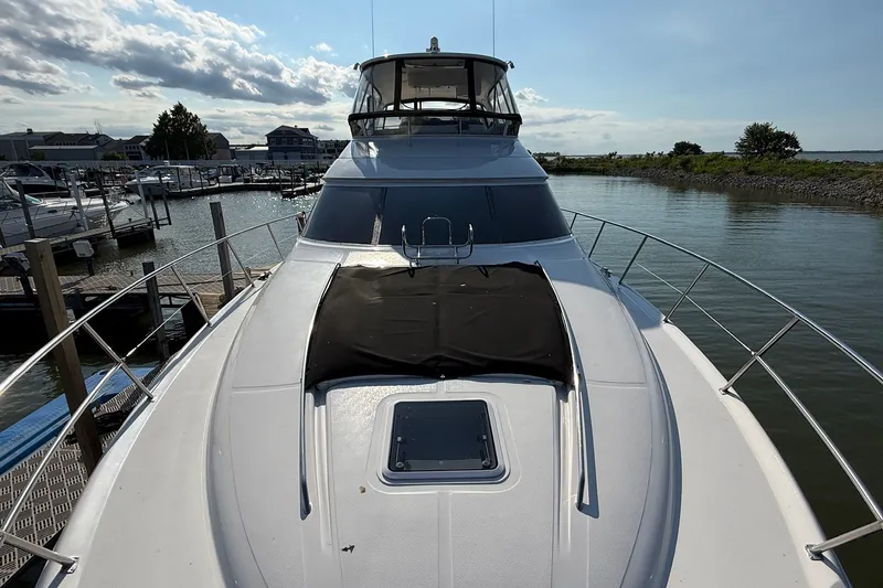 Slide: The Image of 2002 Sea Ray 560 Sedan Bridge yacht docked at marina under clear sky. - 7