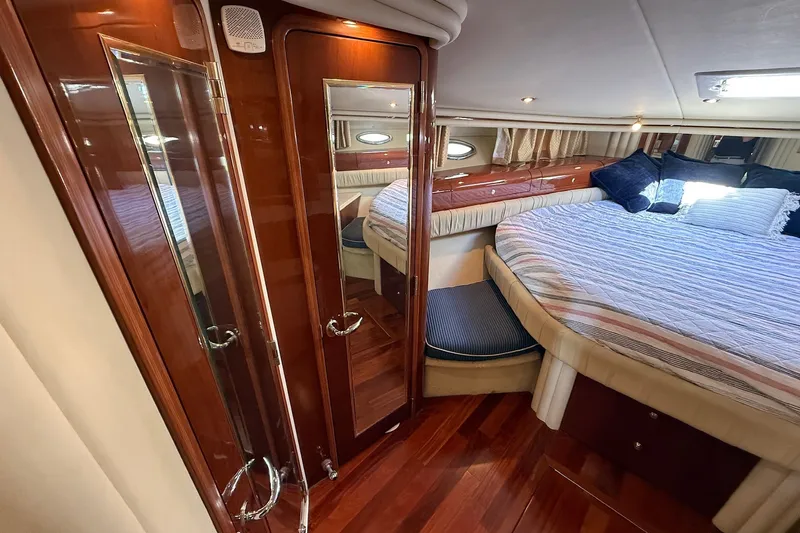 Slide: The Image of Luxurious 2002 Sea Ray 560 Sedan Bridge cabin with elegant wood finishes and cozy bedding. - 94