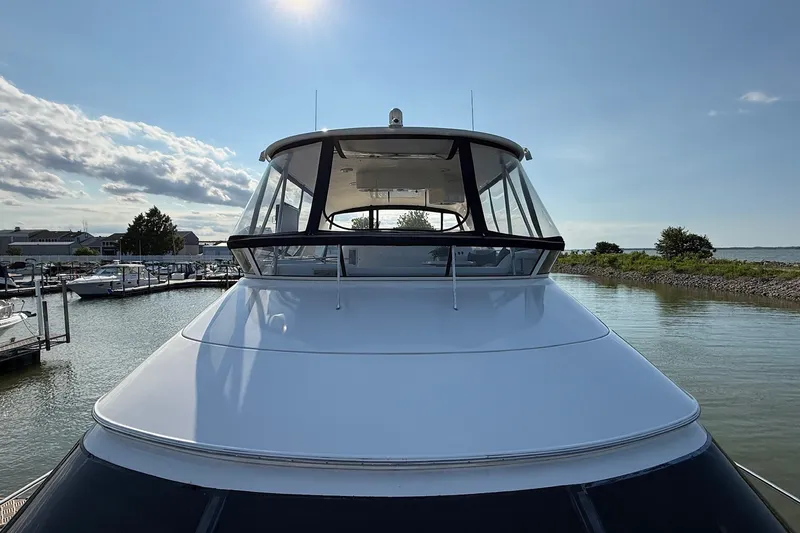 Slide: The Image of 2002 Sea Ray 560 Sedan Bridge yacht docked in a marina under a clear sky. - 8