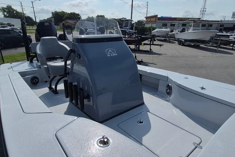 Slide: The Image of 2027 Blazer 675 Ultimate Bay boat interior with console and seating in a dealership lot. - 15