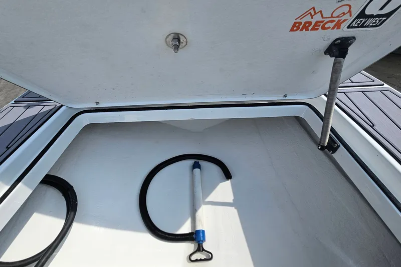 Slide: The Image of Open storage compartment of a 2012 East Cape Fury boat with a hose inside. - 22