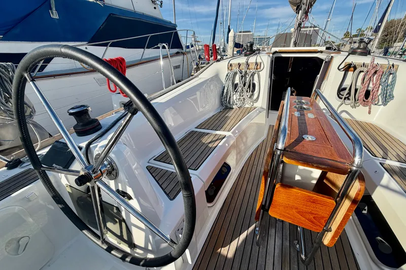 Slide: The Image of Cockpit of 2019 Jeanneau Sun Odyssey 349 sailboat with steering wheel and wooden seating. - 10
