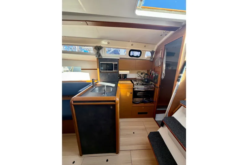 Slide: The Image of Interior of 2019 Jeanneau Sun Odyssey 349 sailboat, featuring a compact kitchen area. - 31
