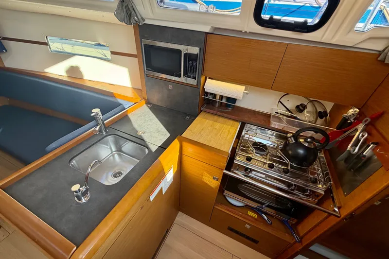 Slide: The Image of Interior of 2019 Jeanneau Sun Odyssey 349 yacht kitchen with sink, stove, and microwave. - 26