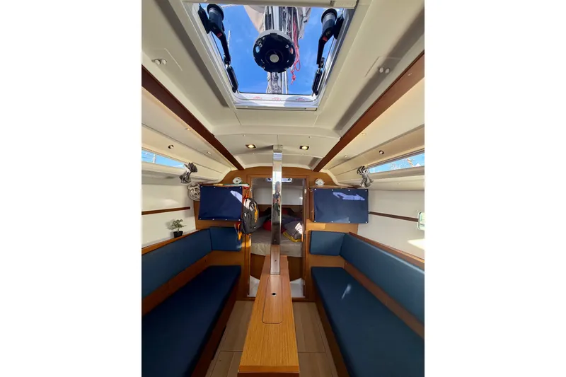 Slide: The Image of Interior of 2019 Jeanneau Sun Odyssey 349 sailboat, featuring cozy seating and wooden finishes. - 21