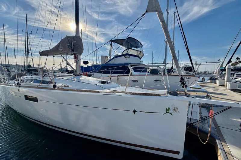 Slide: The Image of 2019 Jeanneau Sun Odyssey 349 sailboat docked at marina under clear sky. - 2