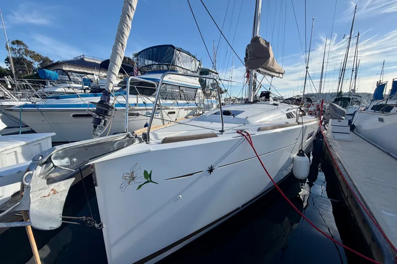 Slide: The Image of 2019 Jeanneau Sun Odyssey 349 sailboat docked at marina under clear blue sky. - 1
