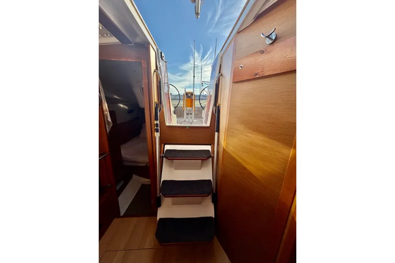 Slide: The Image of Interior view of 2019 Jeanneau Sun Odyssey 349 sailboat, featuring wooden stairs and cabin access. - 29