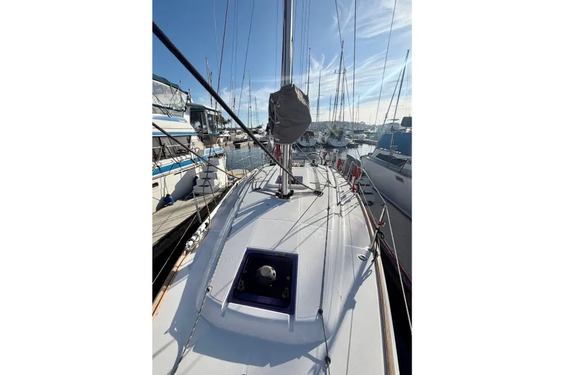 Slide: The Image of 2019 Jeanneau Sun Odyssey 349 sailboat docked in a marina, showcasing deck and rigging. - 16