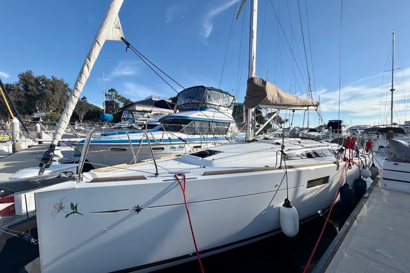 The Image of 2019 Jeanneau Sun Odyssey 349 sailboat docked at marina under clear blue sky. - 0