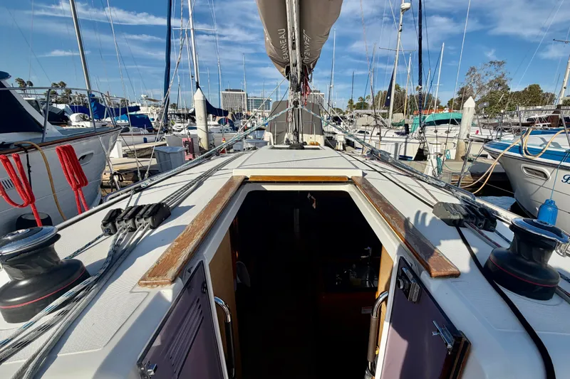 Slide: The Image of 2019 Jeanneau Sun Odyssey 349 sailboat docked at marina, view of deck and open cabin. - 7