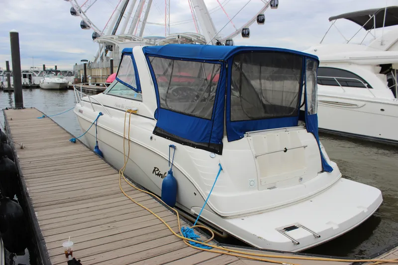 Slide: The Image of 2006 Rinker 290 Express Cruiser docked at marina with blue canopy. - 3