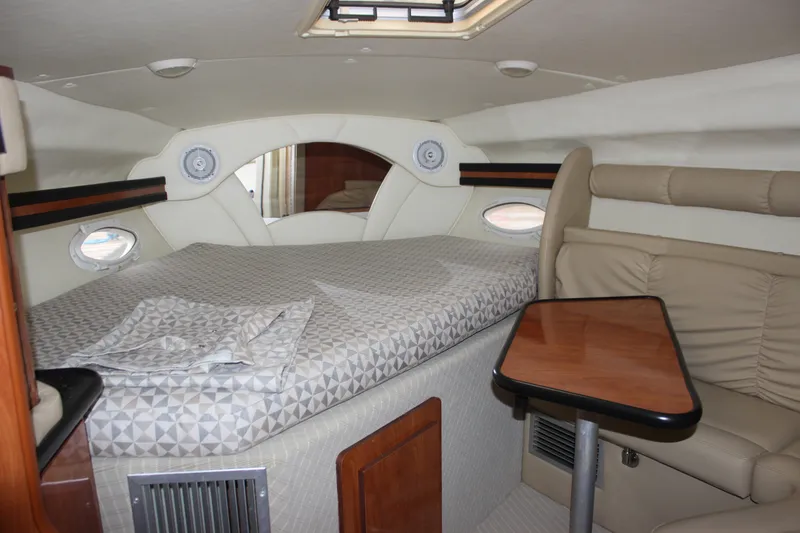 Slide: The Image of 2006 Rinker 290 Express Cruiser cabin interior with bed and seating area. - 19