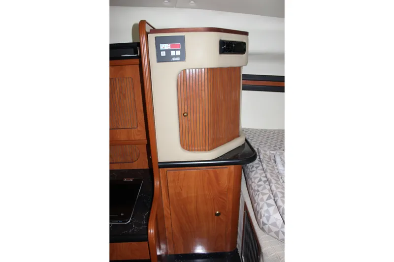 Slide: The Image of Interior of 2006 Rinker 290 Express Cruiser with wood cabinetry and control panel. - 24