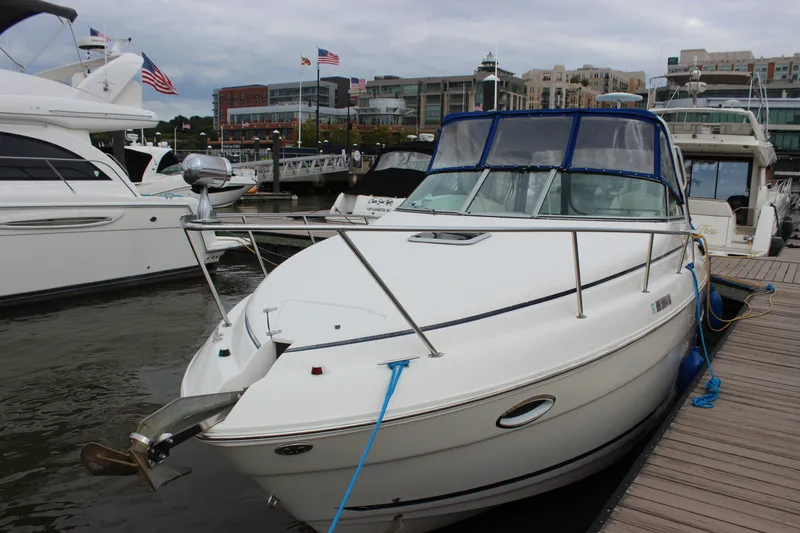 Slide: The Image of 2006 Rinker 290 Express Cruiser docked at a marina with surrounding boats. - 11