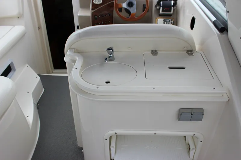 Slide: The Image of 2006 Rinker 290 Express Cruiser interior with sink and storage area. - 13