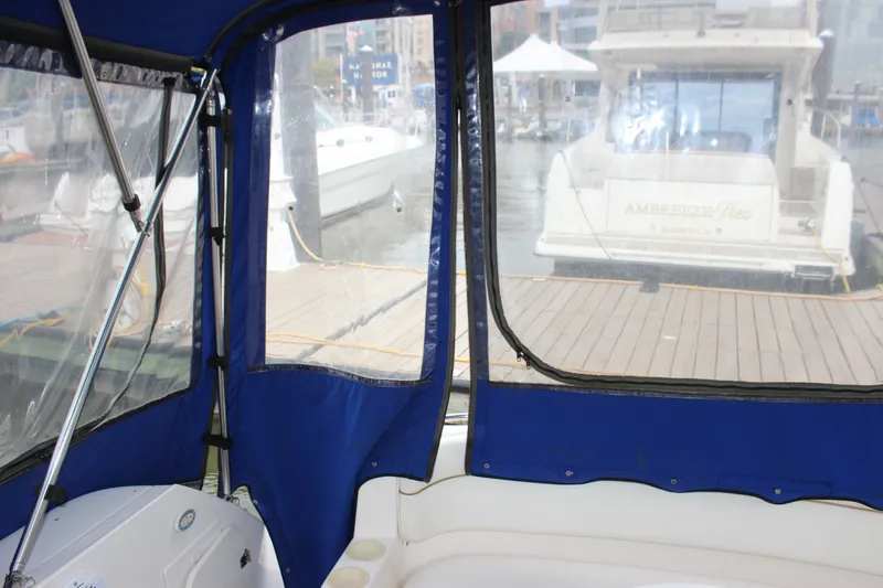 Slide: The Image of Interior view of a 2006 Rinker 290 Express Cruiser with marina backdrop. - 9