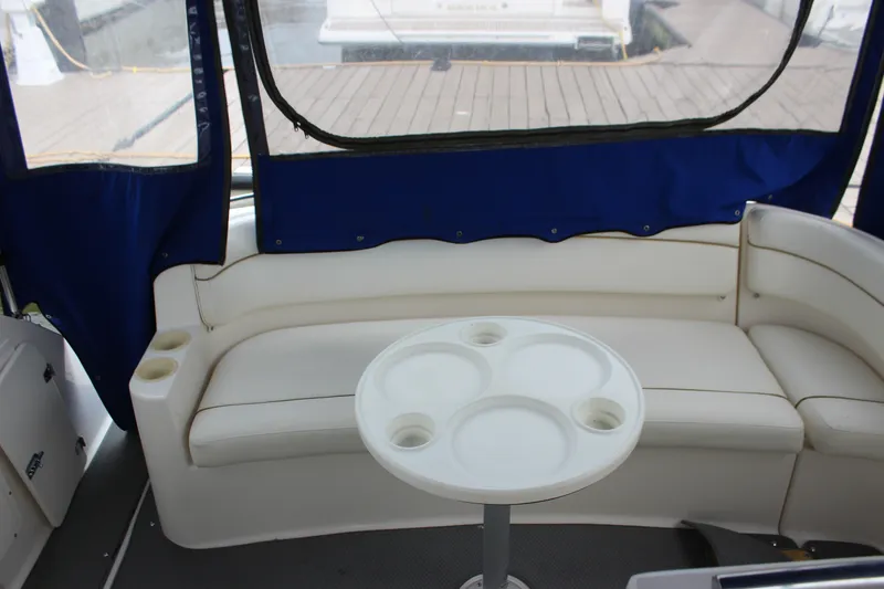Slide: The Image of Interior of 2006 Rinker 290 Express Cruiser with white seating and round table. - 8