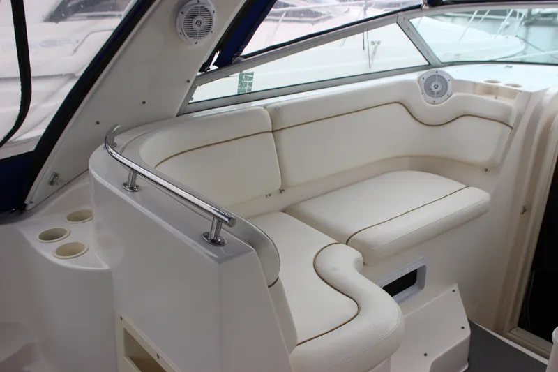 Slide: The Image of 2006 Rinker 290 Express Cruiser interior seating with cup holders and speakers. - 7