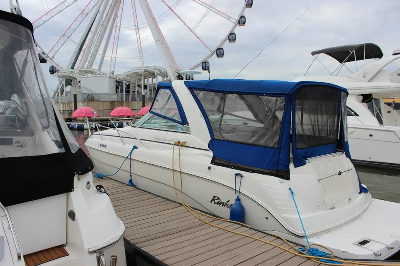 Slide: The Image of 2006 Rinker 290 Express Cruiser docked near a Ferris wheel. - 2