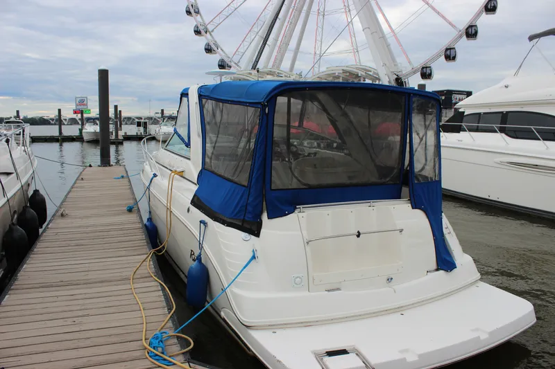 Slide: The Image of 2006 Rinker 290 Express Cruiser docked at marina with ferris wheel in background. - 4