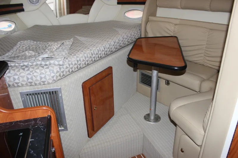 Slide: The Image of 2006 Rinker 290 Express Cruiser interior with bed, seating, and table. - 18