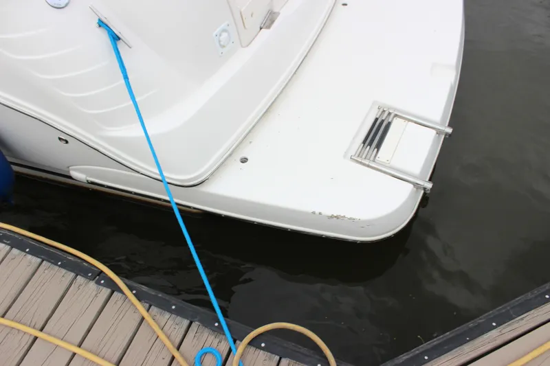 Slide: The Image of 2006 Rinker 290 Express Cruiser docked, showing swim platform and ladder. - 10