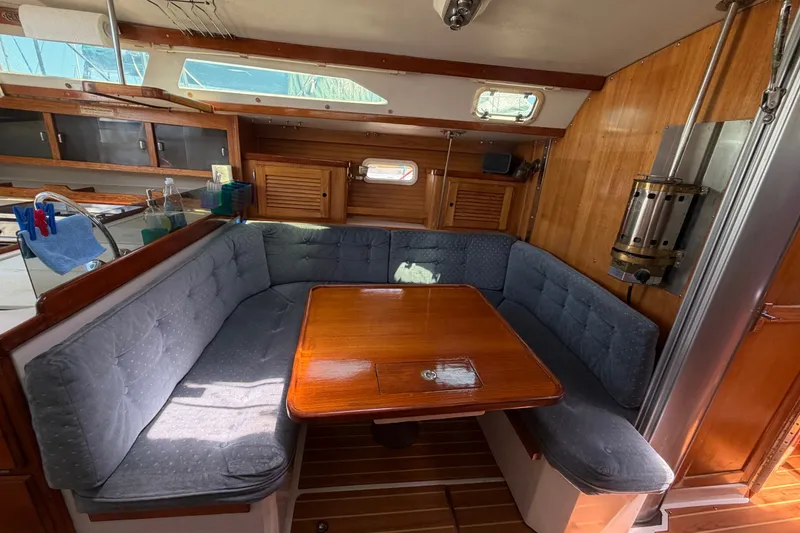 Slide: The Image of Cozy interior of a 1996 Catalina 36 MkII sailboat with cushioned seating and wooden table. - 42