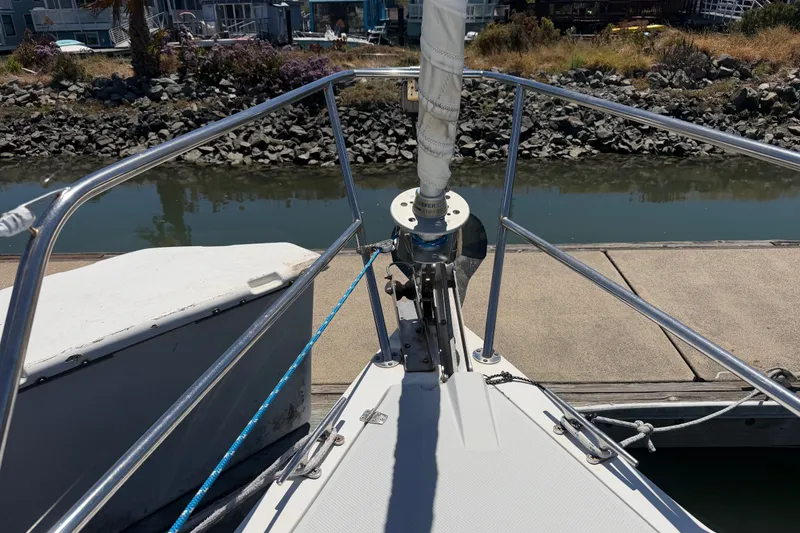 Slide: The Image of Bow of 1996 Catalina 36 MkII sailboat docked by a rocky shoreline. - 16
