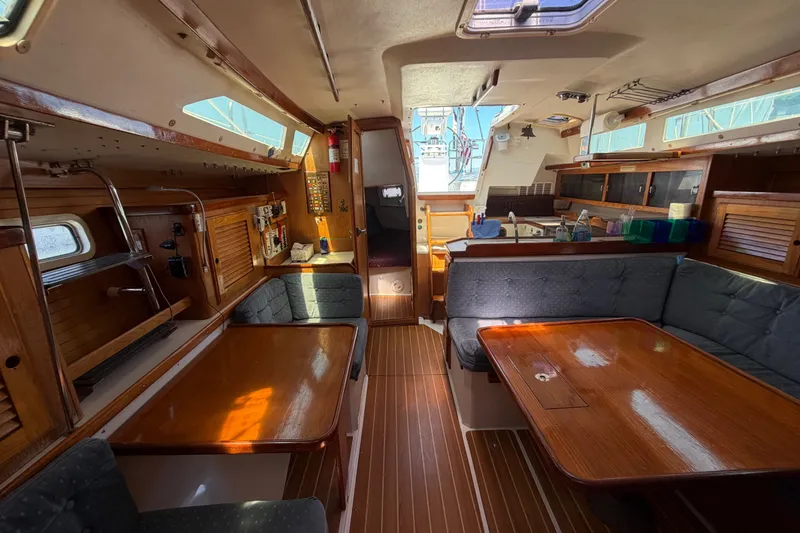 Slide: The Image of Interior of a 1996 Catalina 36 MkII sailboat, featuring a cozy dining area and wooden finishes. - 46