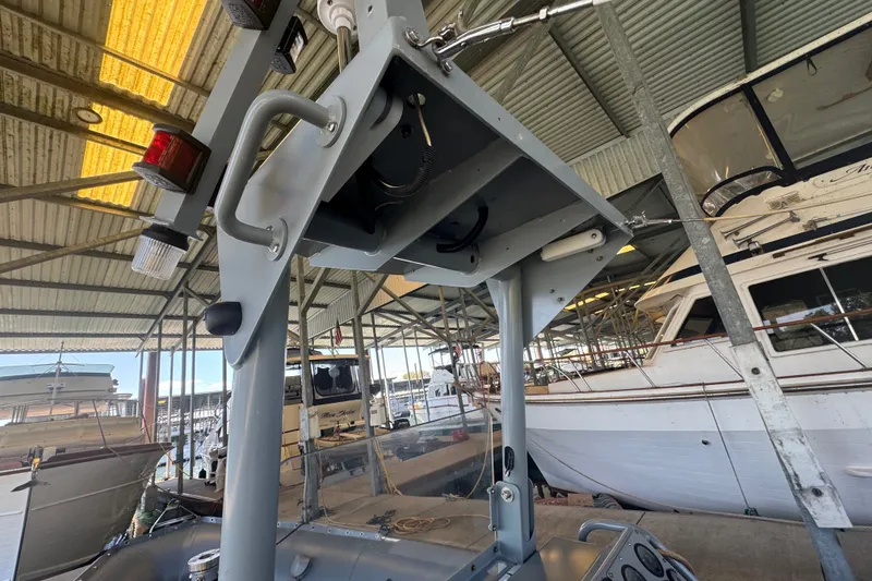 Slide: The Image of 2004 Zodiac Milpro Hurricane boat under a metal canopy in a marina setting. - 27