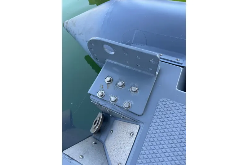 Slide: The Image of Close-up of a 2004 Zodiac Milpro Hurricane boat component with bolts and textured surface. - 34