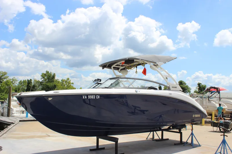 Slide: The Image of 2022 Yamaha Boats 252XE on display at a marina under a bright blue sky. - 23