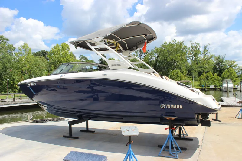 Slide: The Image of 2022 Yamaha Boats 252XE on display at a marina, under a clear sky. - 25