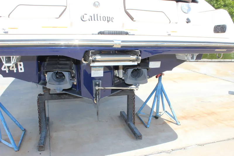 Slide: The Image of Rear view of a 2022 Yamaha Boats 252XE on stands, showcasing dual jet propulsion. - 19