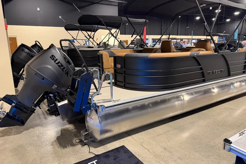 Slide: The Image of 2027 Trifecta 24 RFLE pontoon boat with Suzuki outboard motor displayed indoors. - 19