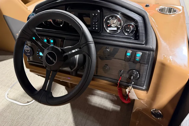 Slide: The Image of Steering wheel and dashboard of 2027 Trifecta 24 RFLE boat, featuring modern controls and gauges. - 17