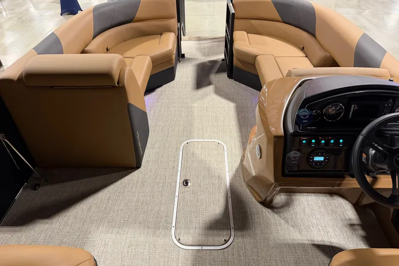 Slide: The Image of Interior of 2027 Trifecta 24 RFLE pontoon boat with tan seating and modern dashboard. - 15